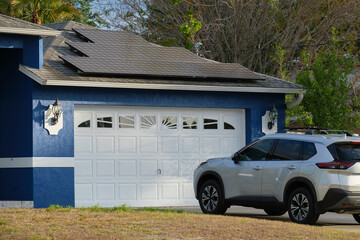 Car parked in front of wide garage double door on concrete driveway of new modern american house