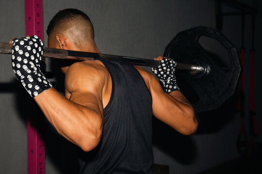 Man with a barbell with weights on his shoulders