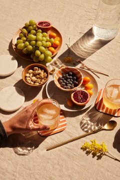 Hand holding a cocktail glass among different foods