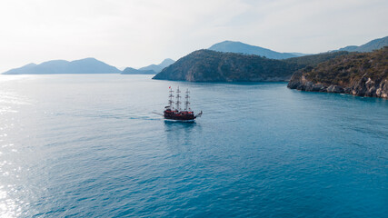 excursion vessel styled as a pirate ship passing by islands