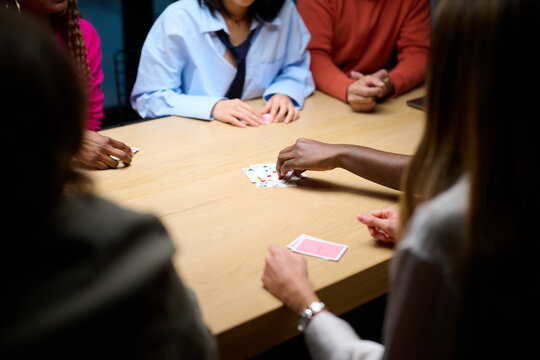 Colleagues playing cards together in office.
