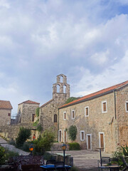 Fototapeta na wymiar Narrow stone street with a big tower in the old town of Budva, Montenegro