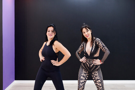 Two smiling women dancing together in a studio