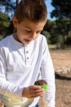 Funny boy inspecting muffin