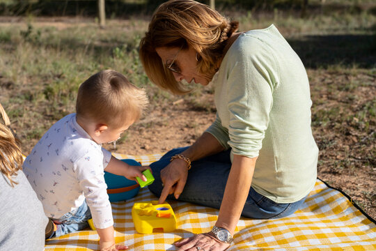 Woman playing with boy on plaid