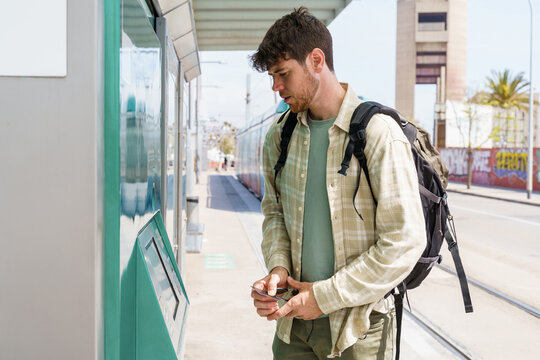 Young man buying metro tickets