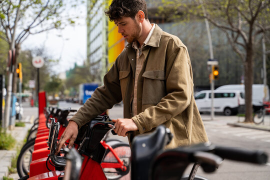 Young man renting bicycle at city