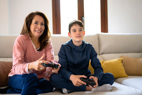 Boy with mother playing video game on couch
