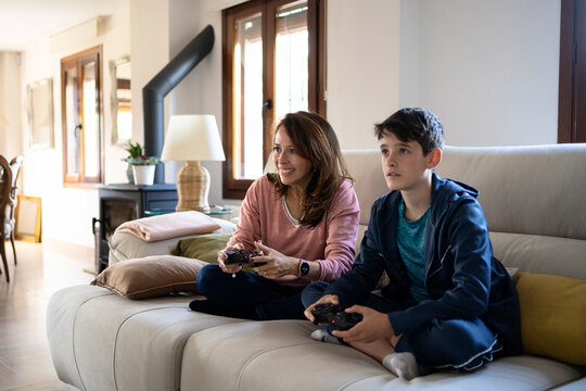 Positive mother and son playing videogame