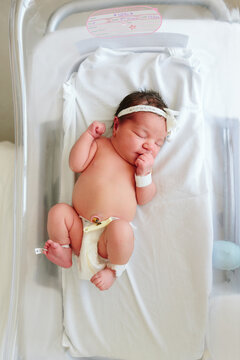 overhead view of newborn baby in hospital bassinet 
