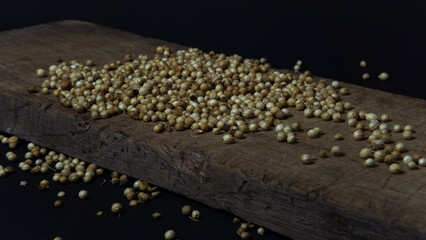 Photo of peppercorns on a wooden board on a black background. Suitable for design elements of spices and organic products.