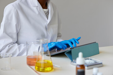 Unrecognizable pharmacist working on tablet