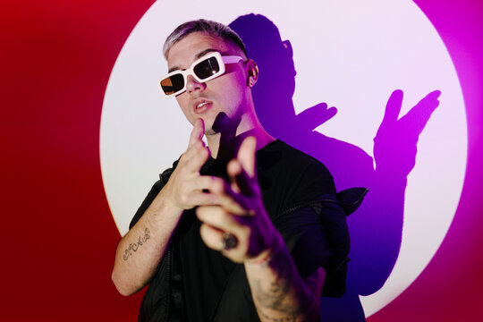 Stylish man in sunglasses pointing at camera