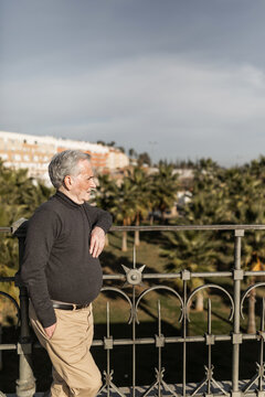70-year-old senior man looking at the city landscape