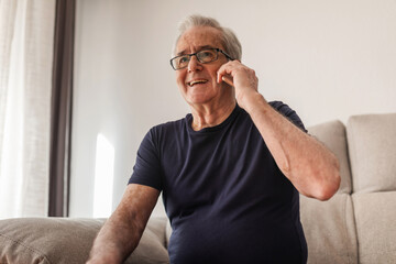 70-year-old man with vitiligo talking on his mobile phone at home
