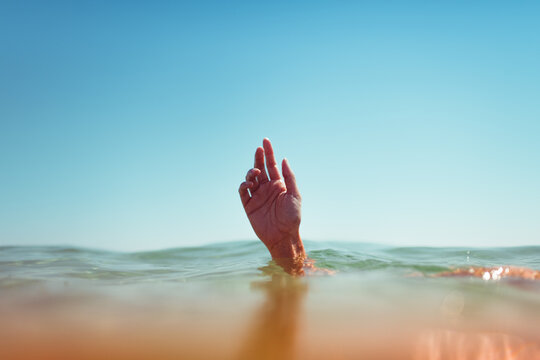 Female hand emerging from the sea