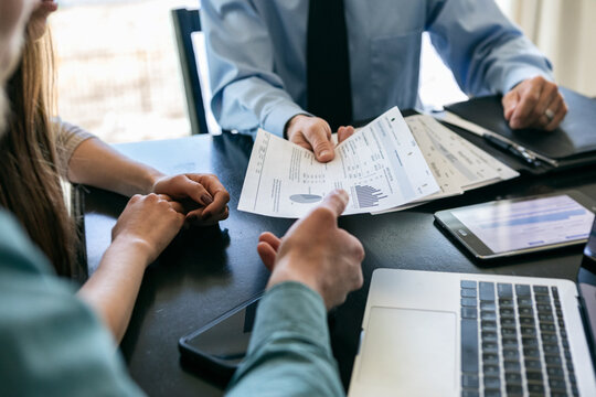Finance Advisor Hands Investment Charts To Client