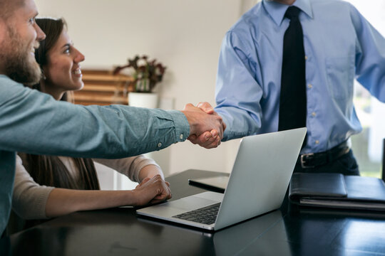 Couple Shakes Hands With Financial Advisor At Home