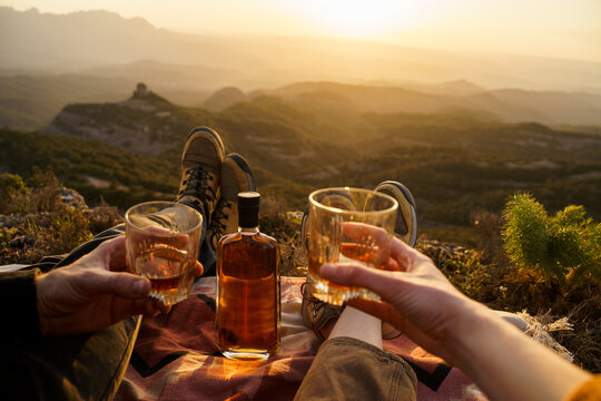 Couple sharing drink at sunset in the mountain