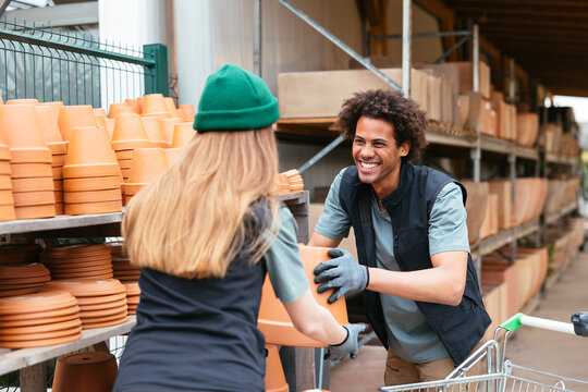 Cheerful colleagues displacing ceramic pots together