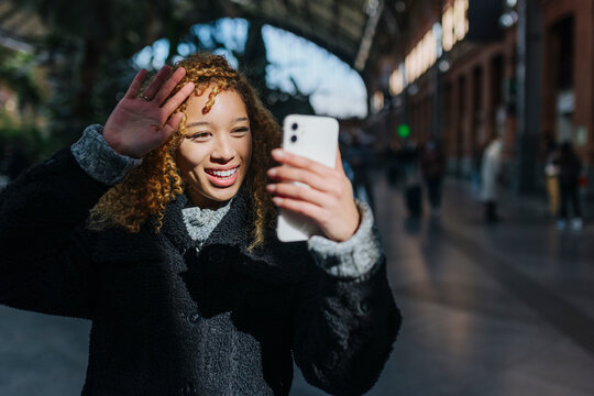 Cheerful woman taking selfie on smartphone