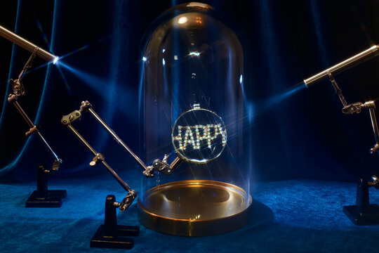 Still life with the jewelry word happy under a magnifying glass