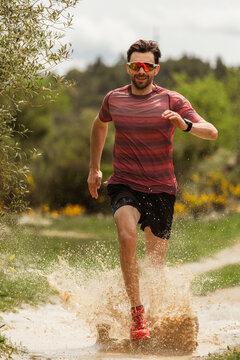 runner splashes on muddy track