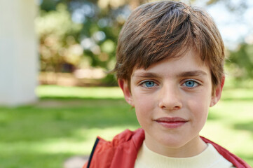 Little boy smiling outside in a park