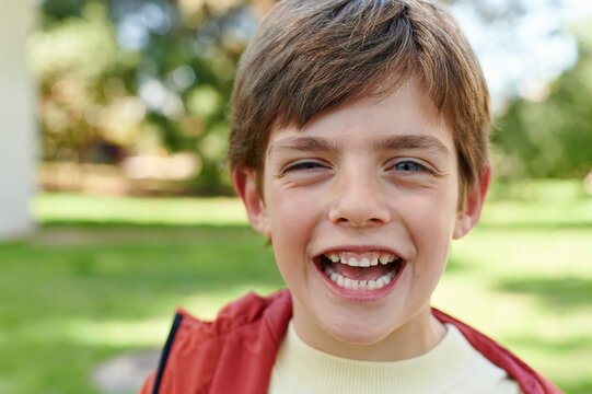 Little boy laughing outside in a park