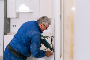 Handyman assembling furniture in new apartment