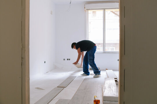 Hispanic man installing floor in new apartment