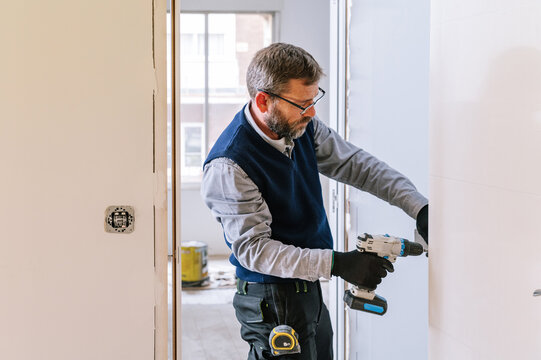 Handyman installing door in apartment