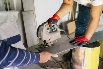 Crop handymen cutting floating floor plank