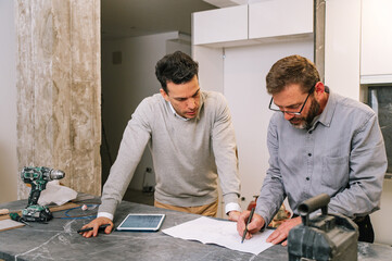 Interior designers examining apartment scheme in kitchen