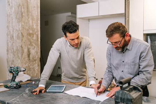 Interior designers examining apartment scheme in kitchen