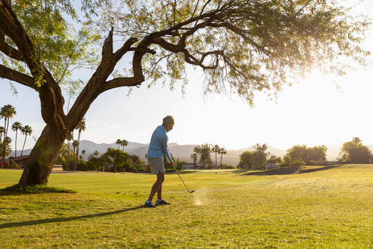 Pretty Senior Citizen hits golf ball 