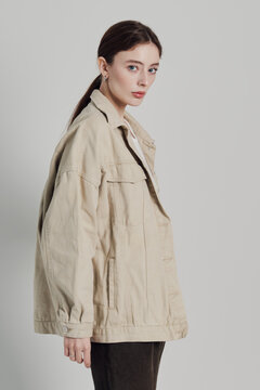Fashion portrait of a young woman in a beige denim jacket