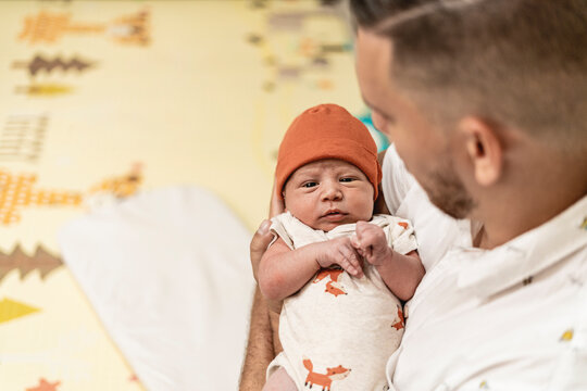 unrecognizable father carrying his infant son