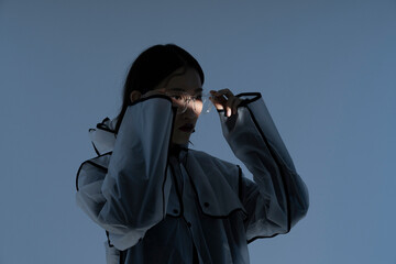 A woman standing in front of the blue background