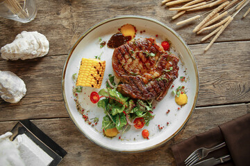 Portion of gourmet grilled beef steak on wooden background