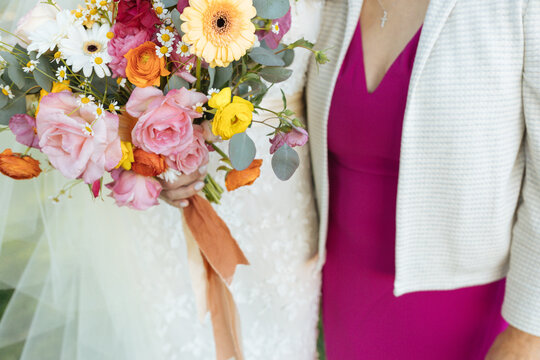 Woman holds pink spring wedding bouquet