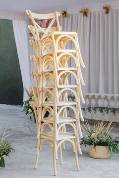 Light wood chairs stacked vertically on an event reception