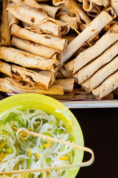 Fried tacos and onions on a yellow plastic bowl