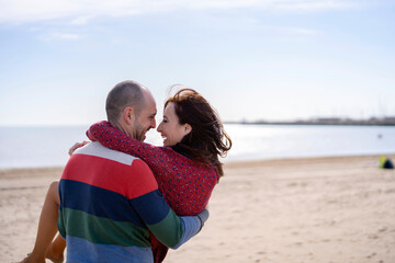 Man carrying woman in arms on beach
