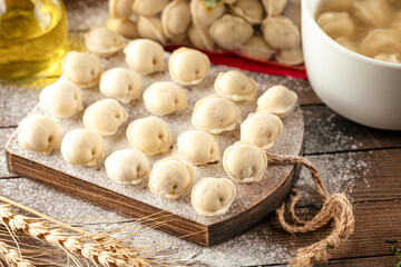 Semi finished pelmeni dumplings on wooden board