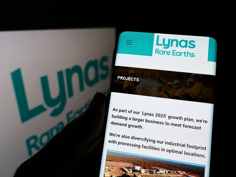 Stuttgart, Germany - 02-26-2022: Person holding cellphone with webpage of Australian mining company Lynas Rare Earths Ltd. on screen with logo. Focus on center of phone display.
