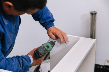 Handyman assembling furniture in new apartment