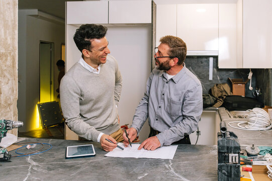 Interior designers examining apartment scheme in kitchen