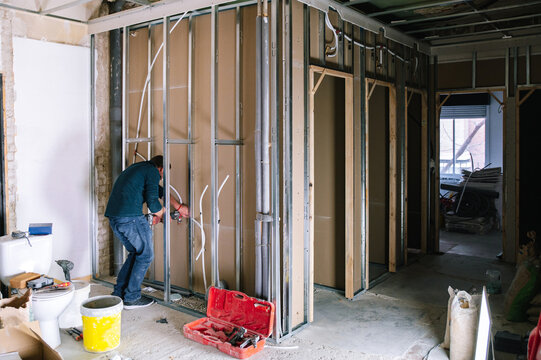 Man installing wall piping in new apartment