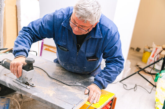 Mature handyman cutting countertop with jigsaw